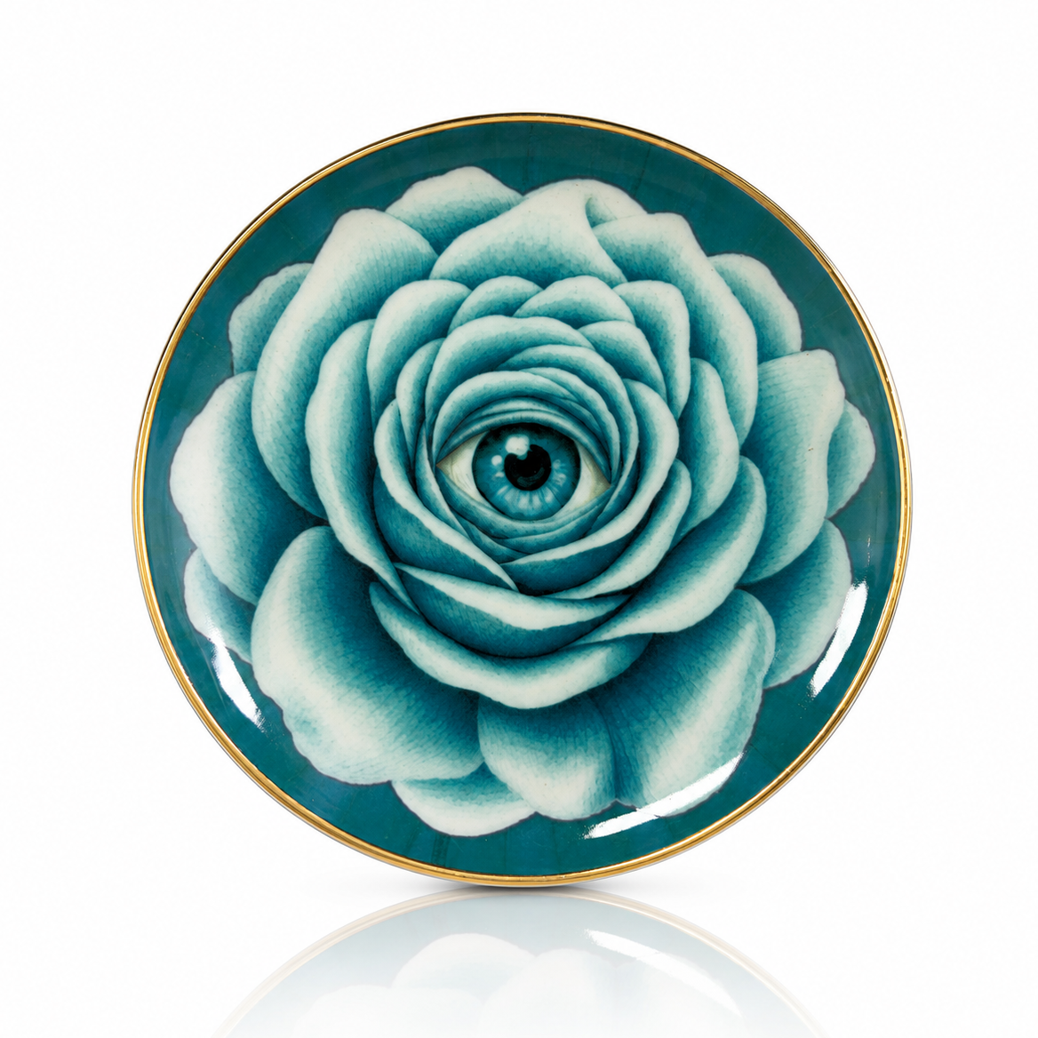A round ceramic plate with a glossy finish, featuring a large teal and white rose design with a human eye in the center, bordered by a thin gold rim, shown on a white background with a soft reflection below.