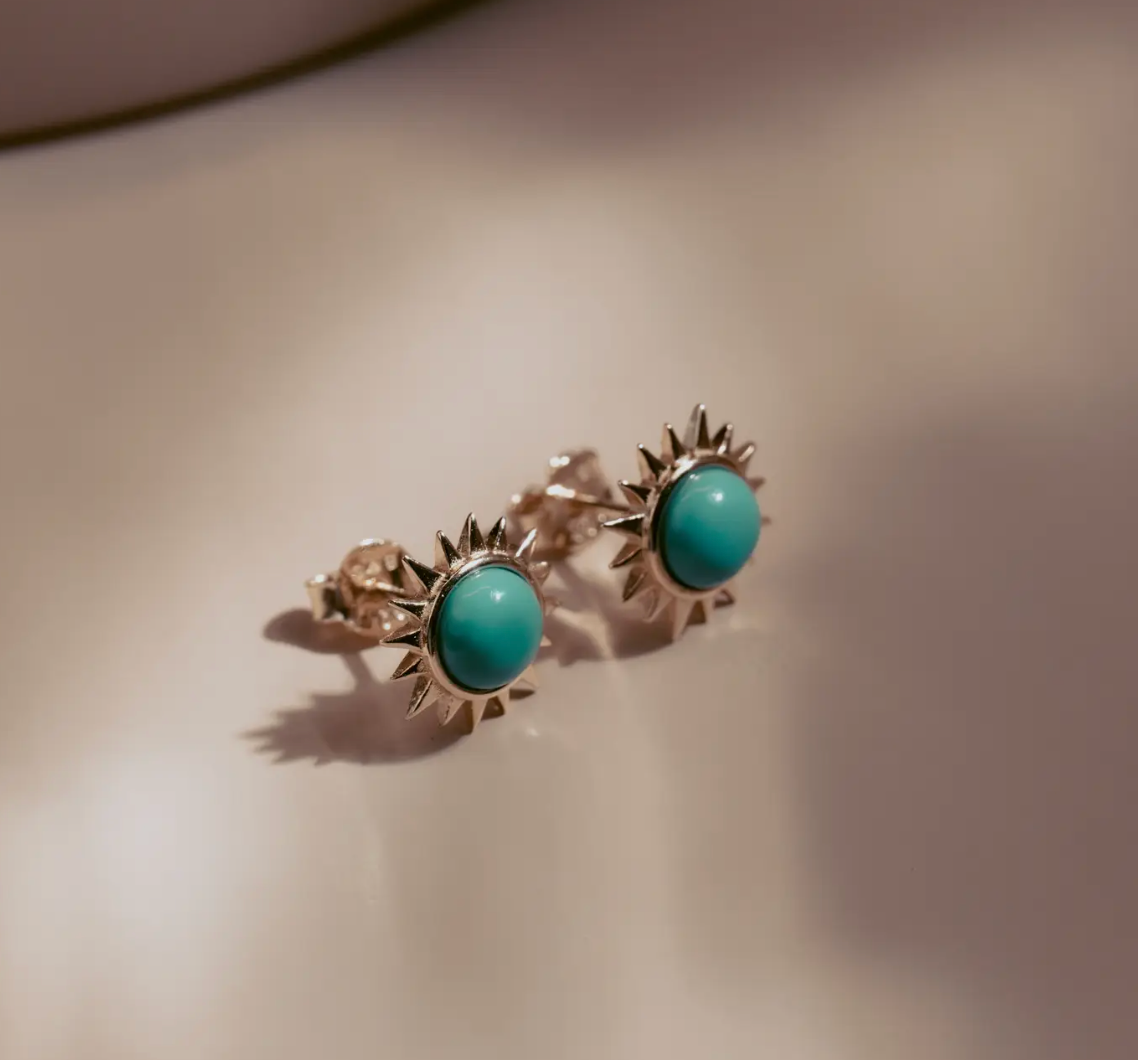 Vibrant and full of energy, the Solar Turquoise Studs channel the power of the sun in bold, golden form. Each earring features a radiant turquoise cabochon encircled by a halo of 14k gold-plated sterling silver rays. Striking and luminous, they bring a touch of modern edge and timeless elegance to any look—perfect for everyday wear or an elevated night out.