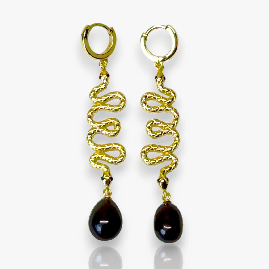 The Serpent Drop Earrings bring a sleek balance of movement and form. Crafted in 14k gold plated over silver, each earring features a sinuous snake design that flows into a dark teardrop pearl. Elegant and commanding, they capture light with every turn, embodying quiet power and refined allure.