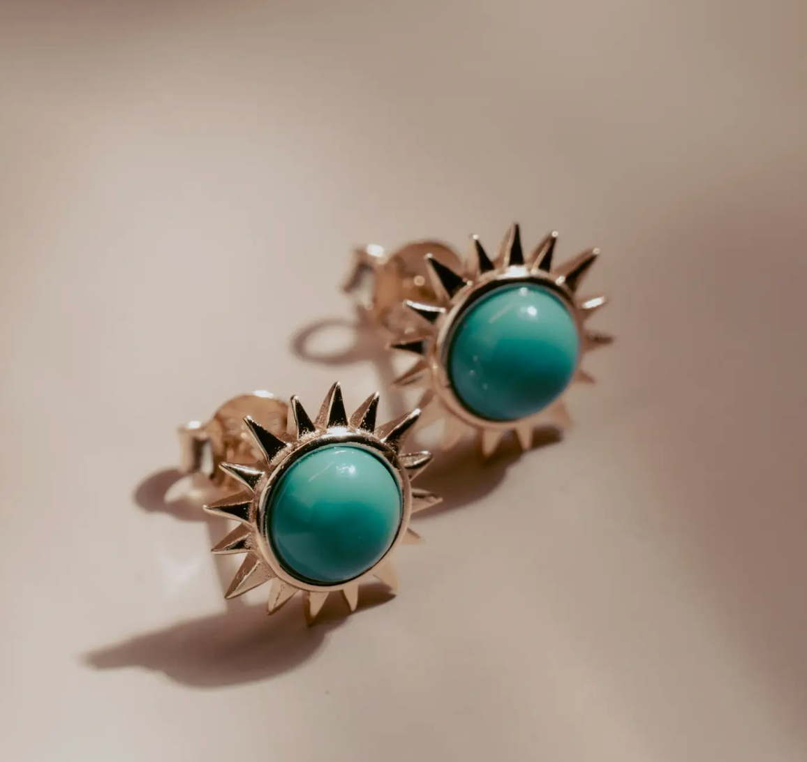 Vibrant and full of energy, the Solar Turquoise Studs channel the power of the sun in bold, golden form. Each earring features a radiant turquoise cabochon encircled by a halo of 14k gold-plated sterling silver rays. Striking and luminous, they bring a touch of modern edge and timeless elegance to any look—perfect for everyday wear or an elevated night out.