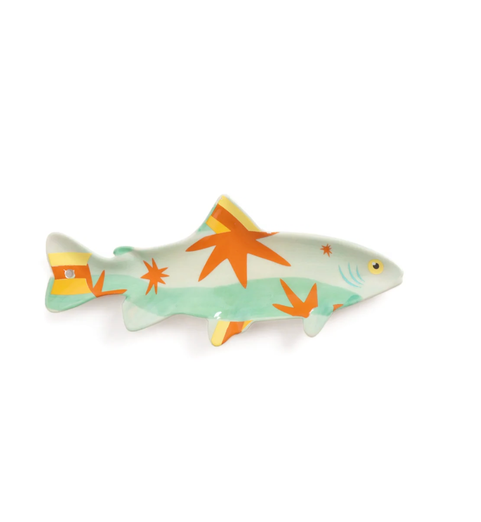 A decorative shark-shaped wall hook or pin featuring a retro design with orange starburst patterns and yellow accents on a mint green and white background, shown against a plain white studio backdrop.